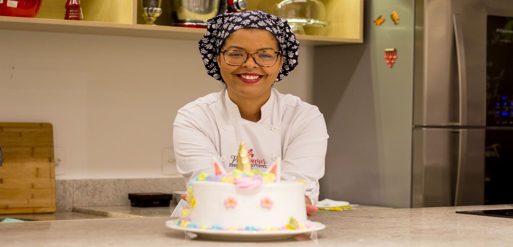 foto da confeiteira patty xavier segurando a o bolo que ela fez