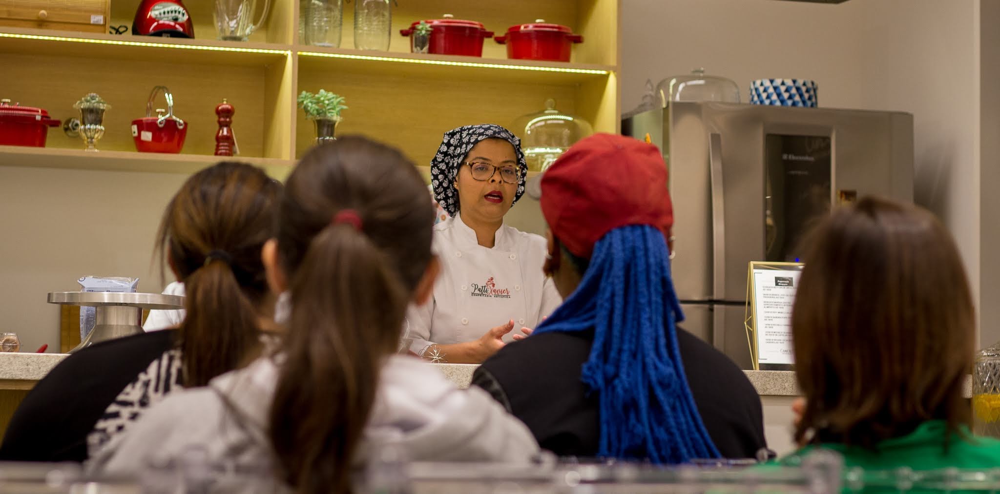 foto da confeiteira patty xavier dando aula junto com seus alunos